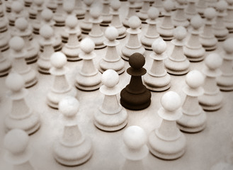 Single black pawn standing out from the crowd. Business concept