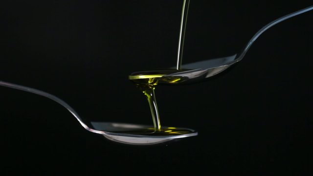 pouring olive oil in a tablespoons