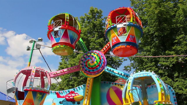 children ride on the carousel in the park