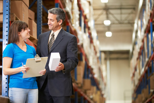 Businessman And Female Worker In Distribution Warehouse