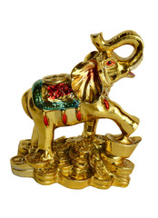 The isolated figurine of an elephant standing on golden coins on