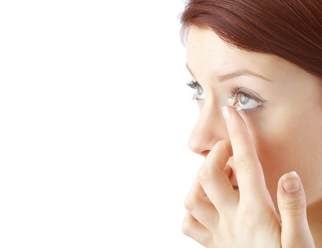 Frau setzt Kontaktlinse ein (weisser Hintergrund)