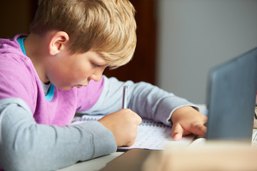Boy Studying In Bedroom Using Laptop