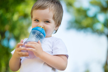 Cute little boy drinking water