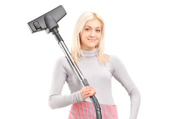 Blond housewife holding a vacuum cleaner