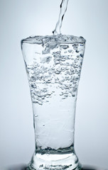 Filling a glass with water showing a drink concept