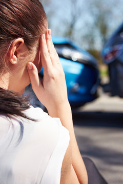 Stressed Driver Sitting At Roadside After Traffic Accident