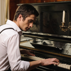 Making music. Profile of a handsome young men playing piano