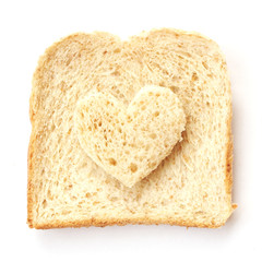 Sliced whole wheat bread with heart shape on white background
