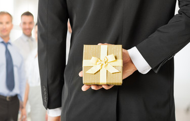 man hands holding gift box in office