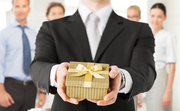 man hands holding gift box in office