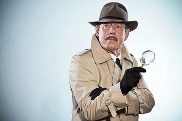 Retro detective man with mustache and hat. Holding magnifying gl - obrazy, fototapety, plakaty