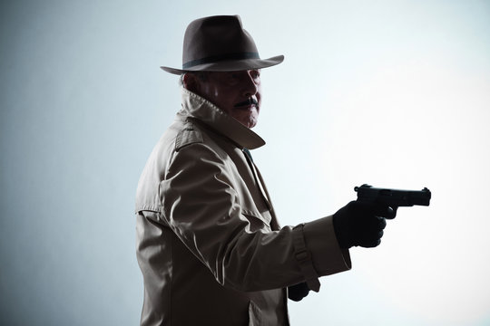 Silhouette of detective with mustache and hat. Holding gun. Stud