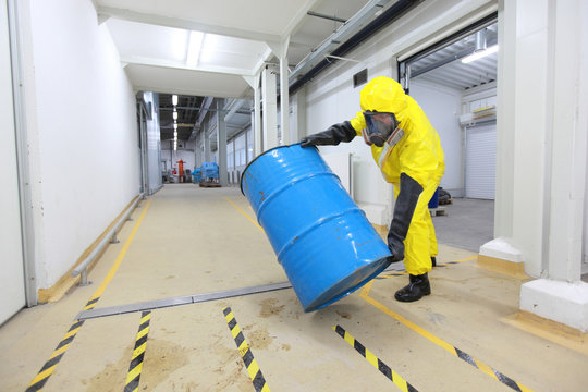 Technician In Uniform Rolling Barrel With Hazardous Substance