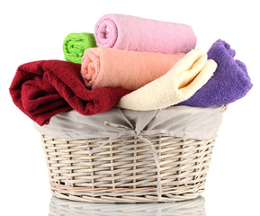 Colorful towels in basket isolated on white
