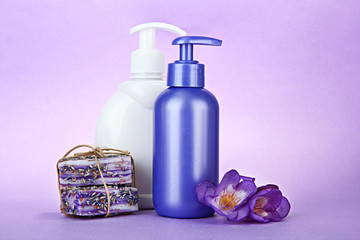 Liquid and hand-made soaps on purple background