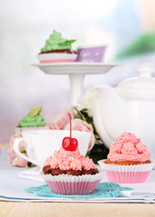 Beautiful cupcakes on dining table on room background
