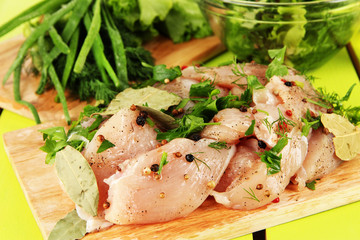 Chicken meat in glass plate,herbs and spices on wooden table