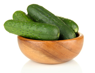 Tasty green cucumbers in wooden bowl, isolated on white