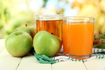 Glasses of juice, apples and carrots