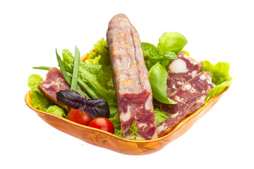Ripe salami with salad, basil, onion and tomato