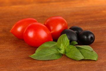 Basil and vegetables on wooden background