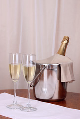 Champagne and glasses on round table on cloth background