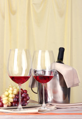Vine and glasses on round table on cloth background