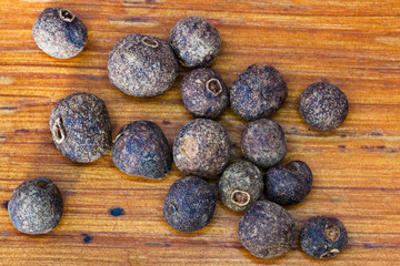 dried allspice spice on wooden board