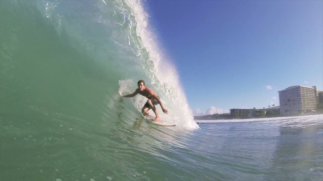 Surfer on Blue Ocean Wave Getting Barreled
