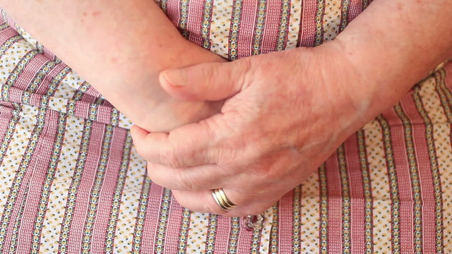 A pair of old hands clasped together