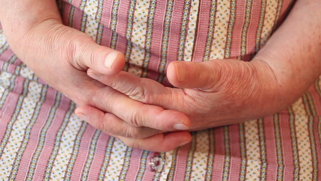 A pair of old hands clasped together