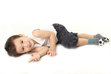 A little boy lie down on the floor.