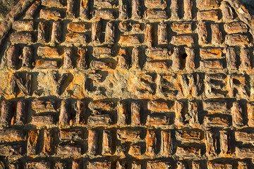 Detail of Rusted Dirty Manhole Cover, with words NYC Sewer