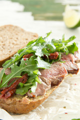 Bun with grilled roast beef and arugula.