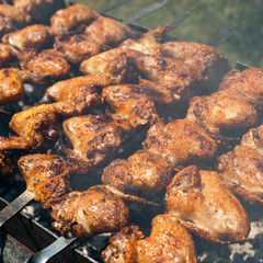 Cooking delicious juicy chicken wings at outdoors grill