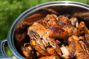 Cooking delicious juicy chicken wings at outdoors grill