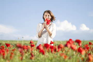 Young casual woman relaxing in poppy field