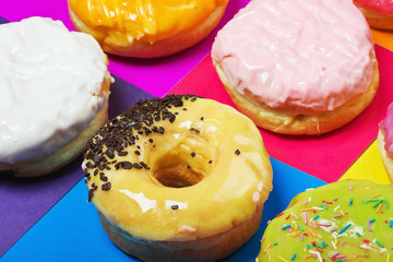 colored glazed donuts on a colored background