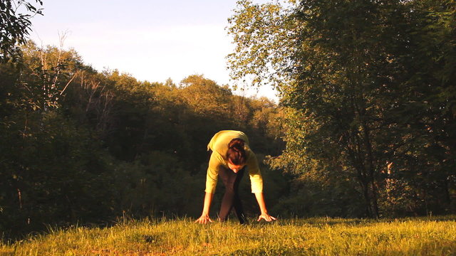 девушка делает упражнения (йога) на природе