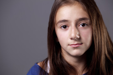 Closeup of a teenage girl's neutral expression.