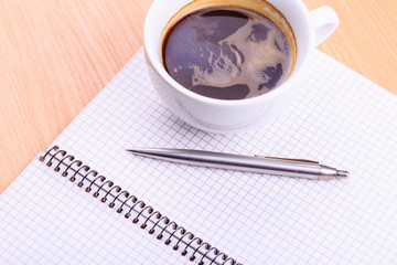 Open blank note book with coffee cup on table