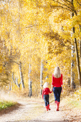 Fototapeta premium mother with her daughter in autumnal alley