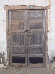 Rustic flaky Black door in Fuerteventura with flaky plaster