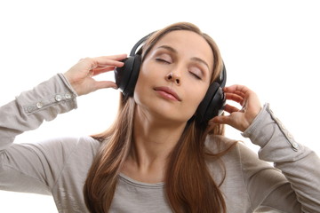 Young woman listening music with headphones, on white