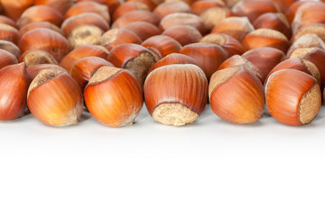 Unbroken hazelnuts on white surface