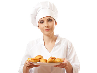Woman chef in uniform holding tray of cookies.