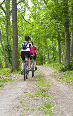Naklejka premium girls biking in the forest