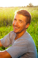 portrait of a handsome young man in a park