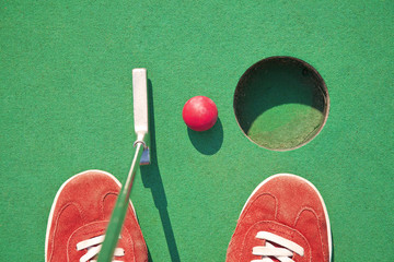 Close-up of miniature golf hole with bat and ball - 53699061